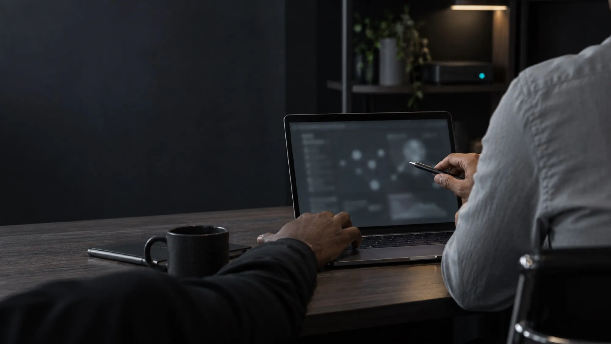 Two colleagues reviewing a laptop screen over the shoulder